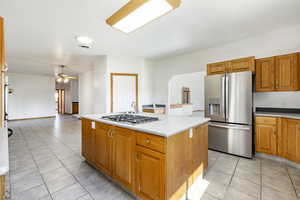 Kitchen featuring stainless steel appliances, light tile patterned floors, light countertops, and a ceiling fan