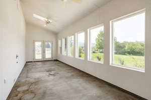 Unfurnished sunroom featuring french doors and lofted ceiling