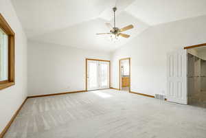 Unfurnished bedroom featuring light carpet, a ceiling fan, and high vaulted ceiling