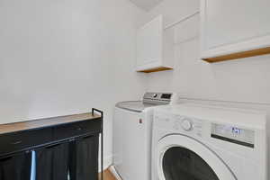 Washroom with cabinet space and washer and dryer