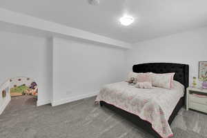 Carpeted bedroom with a textured ceiling and baseboards