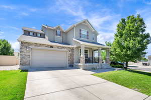 View of front of house featuring a porch, stone siding, stucco siding, and concrete driveway
