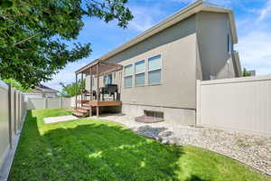Back of house featuring a pergola, a fenced backyard, a wooden deck, and stucco siding
