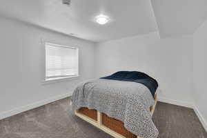 Carpeted bedroom with baseboards and a textured ceiling