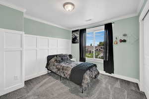 Carpeted bedroom featuring ornamental molding