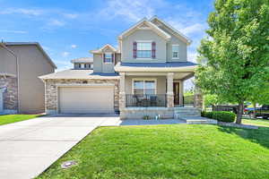 View of front of home with a porch, stucco siding, driveway, and a front lawn