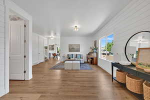 Living room with wood finished floors, a chandelier, and wood walls