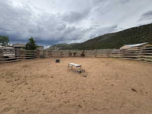 View of yard featuring a mountain view and an outdoor riding arena