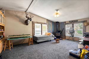 Family Room with a wood stove, carpet floors, and vaulted ceiling