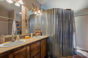 Bathroom featuring double vanity and wood finished floors