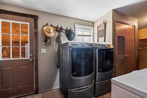 Washroom with washing machine and clothes dryer and baseboards