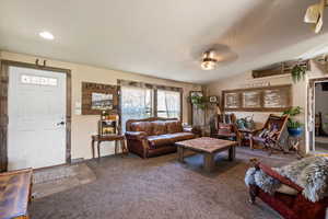Living area with carpet, vaulted ceiling, and recessed lighting