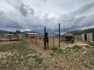 View of yard with a view of rural / pastoral area, an exterior structure, an outbuilding, and a mountain view