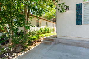 View of side of property featuring stucco siding and a patio