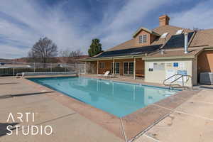 Community pool with french doors and a patio