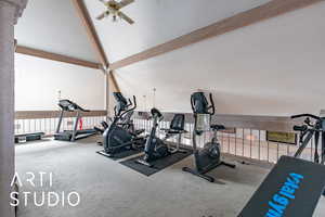 Workout room with carpet floors, a ceiling fan, and high vaulted ceiling