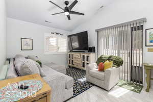 Living room with a ceiling fan and lofted ceiling