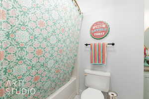 Bathroom featuring shower / bath combo and baseboards