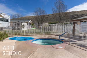 View of swimming pool with a hot tub, a mountain view, and a patio area