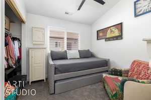 Bedroom with dark colored carpet, lofted ceiling, and ceiling fan