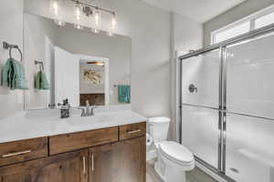 Full bath with vanity, a stall shower, ceiling fan, and wood finished floors