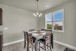 Dining space featuring wood finish floors and a chandelier