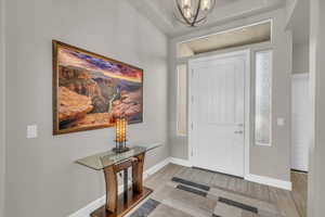 Entryway featuring wood finish floors and a chandelier