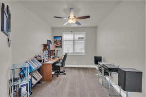 Carpeted office featuring ceiling fan and baseboards
