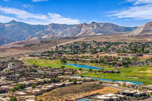 View of mountain background featuring a golf course, a large body of water, and nearby suburban area