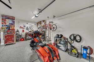 Garage featuring a garage door opener and baseboards