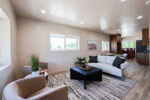 Living room featuring light wood finished floors, recessed lighting, and a textured ceiling