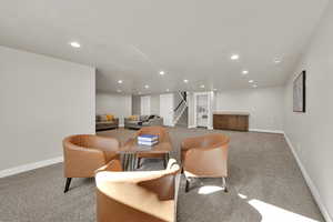 Dining room with light colored carpet, recessed lighting, and stairs