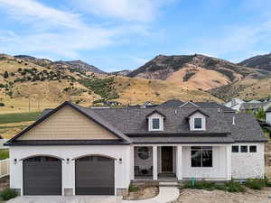 View of front of house with a porch, board and batten siding, driveway, and a mountain view