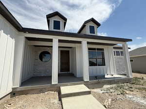 Entrance to property featuring covered porch and board and batten siding