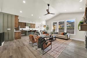 Living room featuring recessed lighting, vaulted ceiling, ceiling fan, light wood-style flooring, and a mountain view
