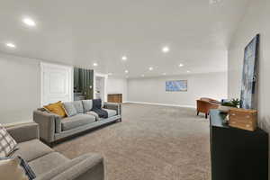 Carpeted living room with recessed lighting, stairway, and built in shelves