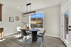 Dining room with light wood finished floors and recessed lighting
