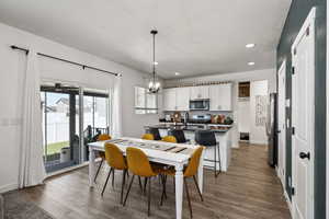 Dining room with a chandelier, wood finished floors, recessed lighting, and a textured ceiling