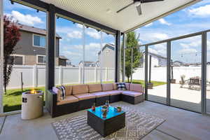 Sunroom featuring ceiling fan, a residential view, and an outdoor living space with a fire pit