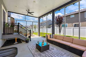 Sunroom featuring an outdoor hangout area, a ceiling fan, and a residential view