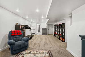 Living area featuring carpet flooring, recessed lighting, and stairway