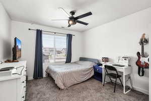 Bedroom with carpet flooring, a desk, and a ceiling fan