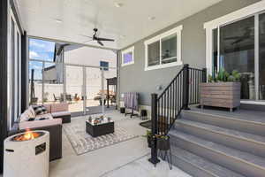 View of patio with an outdoor living space with a fire pit and a ceiling fan