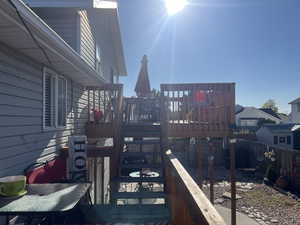 Wooden terrace with a fenced backyard