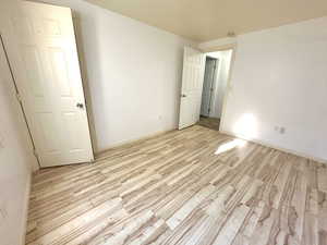 Empty room with light wood finished floors and a smoke detector
