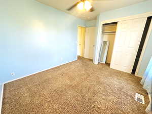 Unfurnished bedroom with a closet, carpet floors, and ceiling fan