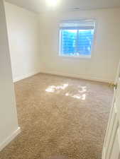 Carpeted spare room with baseboards