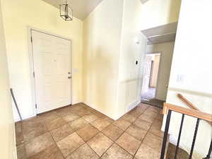 Foyer entrance with baseboards and high vaulted ceiling