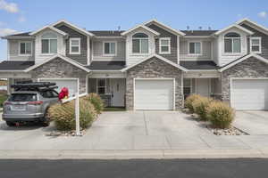 Craftsman-style house featuring stone siding, concrete driveway, a garage, and roof with shingles
