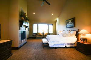 Bedroom with carpet flooring, high vaulted ceiling, a tiled fireplace, and recessed lighting